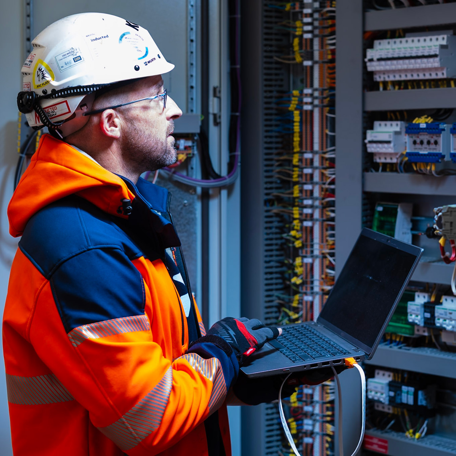 Man inspecting a datacenter with laptop.